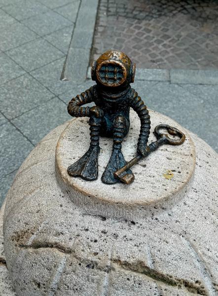 Kolodko Mihály Búvár és a kulcs miniszobra a New York Palota közelében található. A piciny bronzfigura egy tűzcsap tetején ül, és őrzi a mellette lévő kulcsot, amely a New York Kávéházat nyitja.  Fotó: Schindlerné Králl Krisztina