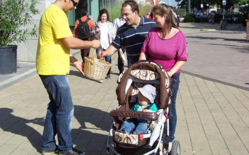Erdei Péter aktivista egy családot kínál almával