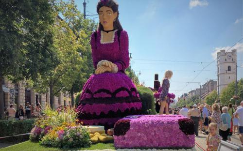 Szinyei Merse Pál Lila ruhás nőfigurája a Fórum virágkocsiján